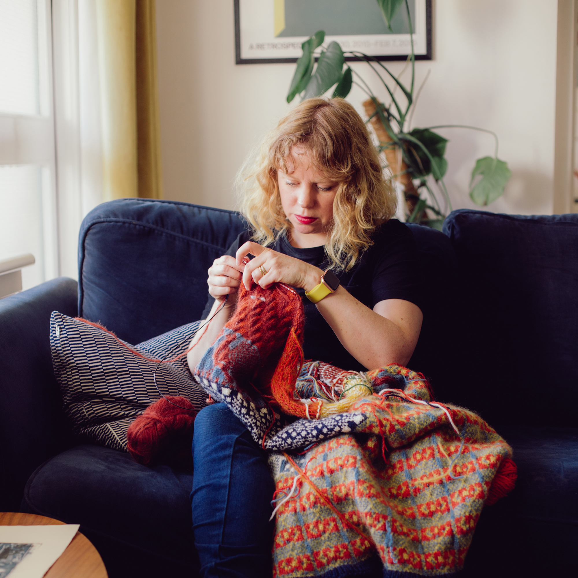 Jeni Allison on the sofa knitting / Image by Laura Prieto Martin